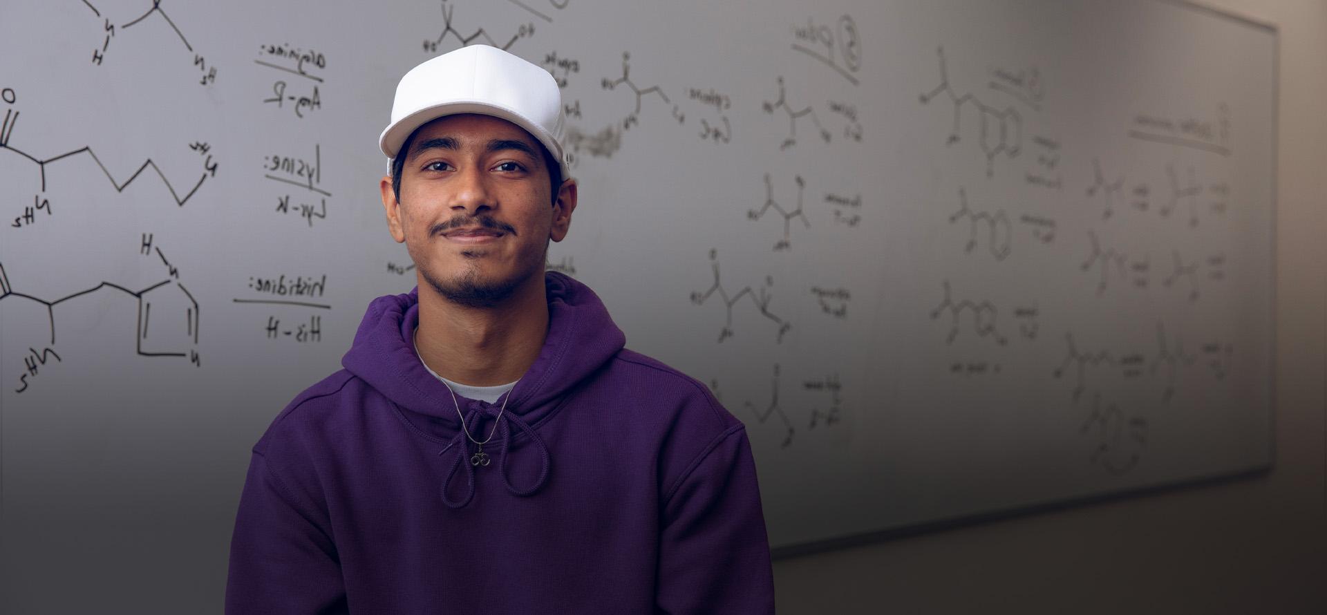 FAU Student tutor smiling in front of white board